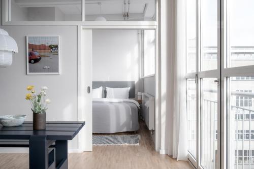 哥本哈根Beach Trail apartments by Daniel&Jacob's的卧室配有白色的床、桌子和窗户。