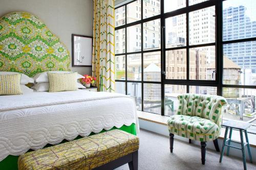 纽约惠特比酒店的一间卧室配有一张床、一把椅子和窗户。