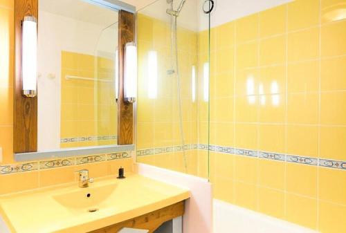 马翁普拉日堡Les appartements de Belle Dune - maeva Home - Appartement 2 pièces 4 person 294的黄色的浴室设有水槽和镜子