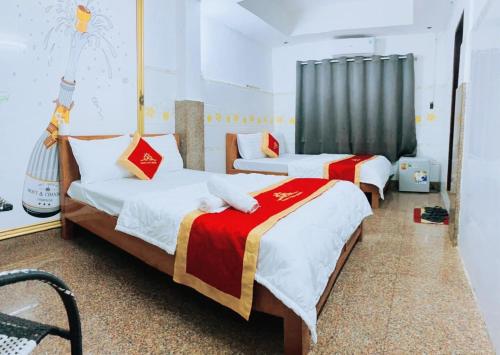 胡志明市Trung Bảo Hotel的一间带两张床和椅子的房间