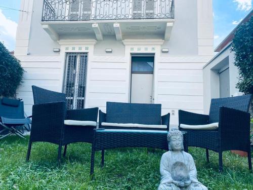 莱科Villa Martina Retreat的坐在房子前面的草上的一个雕像