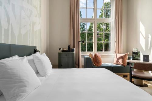 阿姆斯特丹The College Hotel Amsterdam, Autograph Collection的卧室配有白色的床和窗户。