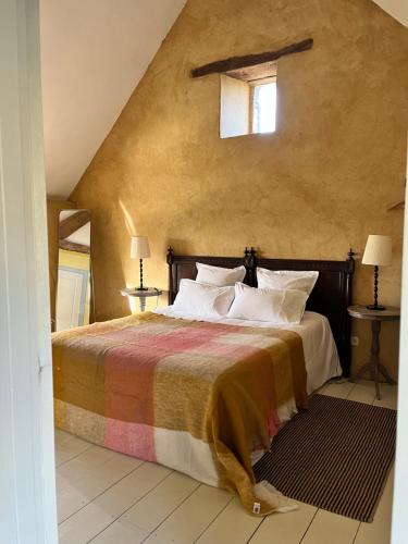 多尔德布列塔尼Domaine du tertre ychot的一间卧室设有床、两张桌子和一扇窗户