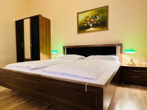 维也纳列支敦士登旅馆的卧室内的一张大床,配有两盏灯