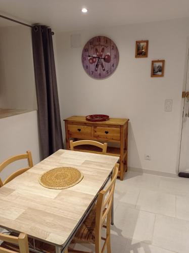 布里昂松La marmotte的一间设有桌子和墙上时钟的餐厅