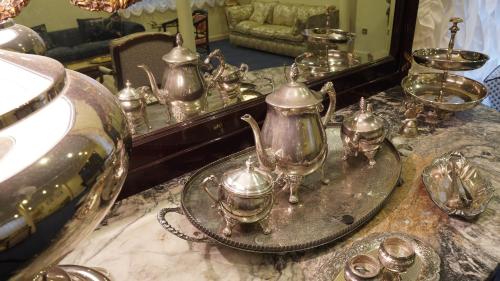 里亚萨HOTEL RIAZA的浴室柜台配有镜子和一些茶壶和杯子