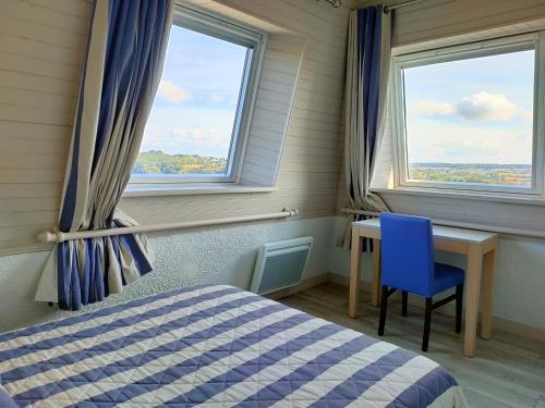 莱扎德里约滨海酒店的一间卧室配有一张床、一张书桌和两个窗户。