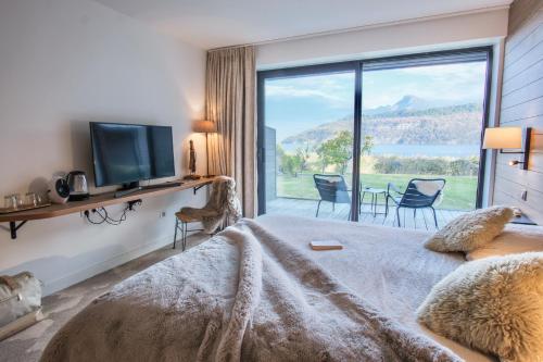 杜约特Villa Caroline, Lac d'Annecy的一间卧室设有一张床和一个大窗户