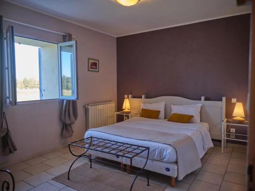 蒙特Mas de l'Estiou的一间卧室设有一张大床和一个窗户。