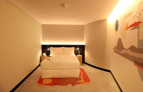 阿布扎比AUHotel - Zayed International Airport的卧室配有一张床,墙上挂有绘画作品