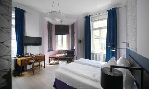维也纳维也纳贝多芬酒店的酒店客房配有一张床、一张书桌和一张书桌。