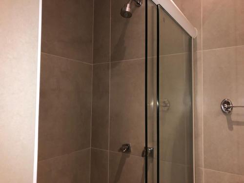 尼泰罗伊尼泰罗伊培亚格兰德酒店的浴室内带玻璃门的淋浴间