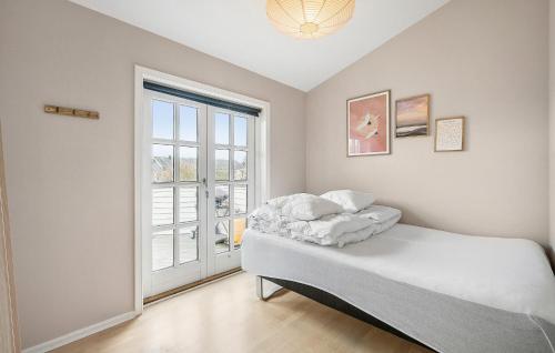 尼堡Nice Home In Nyborg With Kitchen的一间卧室设有一张床和一个大窗户
