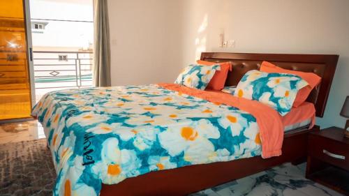 QPT的一间卧室配有一张带蓝色和橙色棉被的床