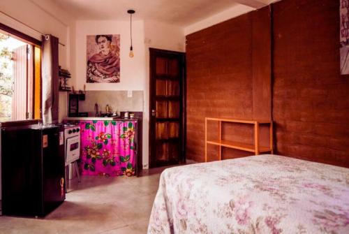 戈亚斯州上帕莱索Daya Ma Hospedagem的一间设有厨房和一张位于客房内的床的房间