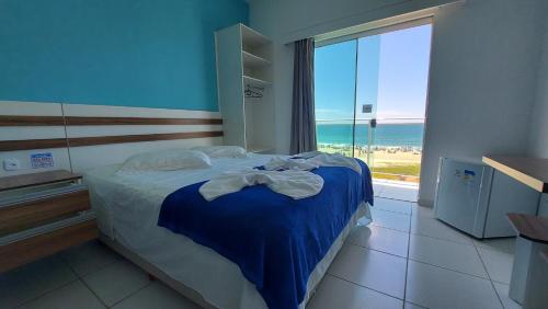 瓜拉图巴海蓝宝石酒店的一间卧室设有一张床,享有海景