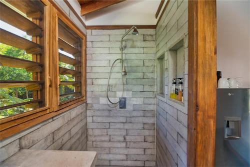 罗阿坦Camp Bay Lodge的砖墙内带淋浴的浴室