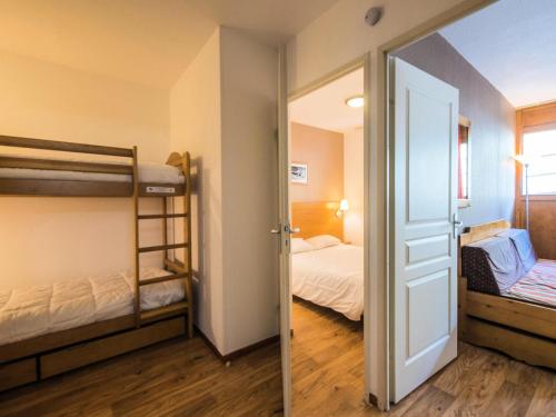 奥尔西埃Appartement 2 Pièces Cabine 6 Personnes - été 324的一间设有两张双层床的客房和一扇通往卧室的门
