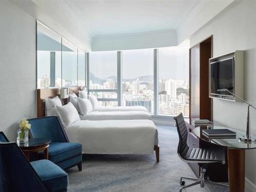 香港香港康得思酒店的酒店客房设有白色的床和大窗户。