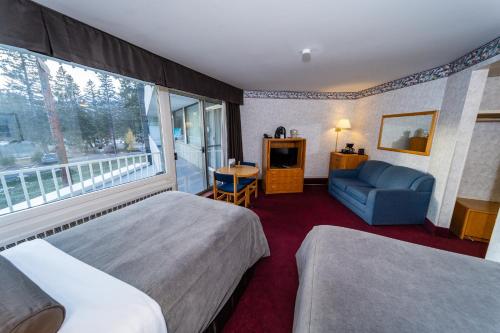 班夫包湖景观酒店的酒店客房带两张床、椅子和窗户