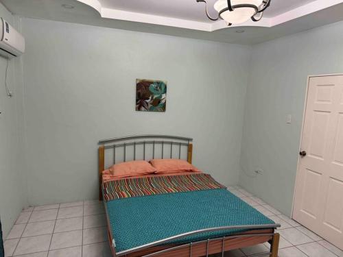 Diego MartinTownhouse in Diego Martin的白色墙壁的房间里一张小床