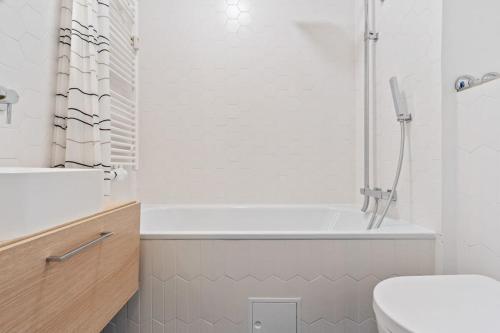 卢森堡Elegant 1BR Apt, Balcony, Pool, Central Location的白色的浴室设有浴缸和卫生间。