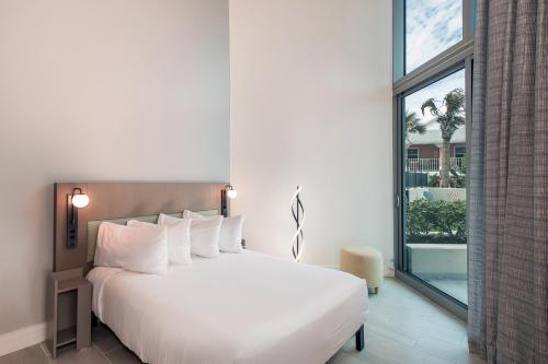 代托纳海滩Max Beach Resort的卧室设有白色的床和大窗户
