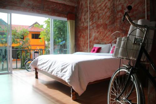 查汶苏梅岛帕瑟旅舍的卧室配有自行车停放在床边
