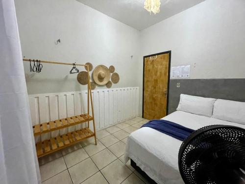 图托亚Mini Hostel的卧室配有一张床,墙上挂着一顶帽子