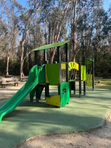 SERRA DI FIUMORBOles bungalows de Lisa Maria的公园内一个带绿色滑梯的游乐场