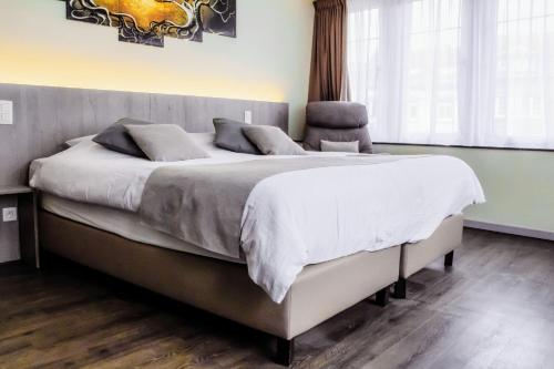 胡法利兹Hotel des Postes的一间卧室配有一张带白色床单的大床