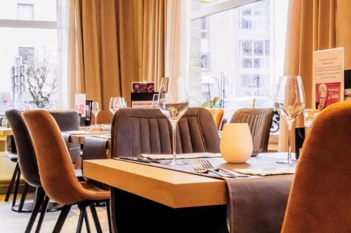 胡法利兹Hotel des Postes的配有桌椅和酒杯的餐厅