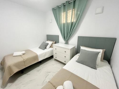 莫罗德哈布雷Jandia Beach Apartment 2的一间卧室设有两张床和窗户。