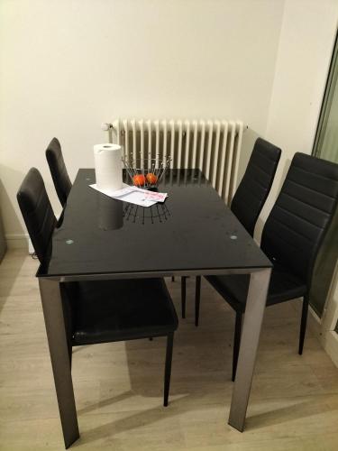 图尔Keva apartment的黑色餐桌,配有黑色椅子和散热器