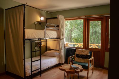 圣卡洛斯-德巴里洛切Selina Bariloche的一间卧室配有双层床和椅子