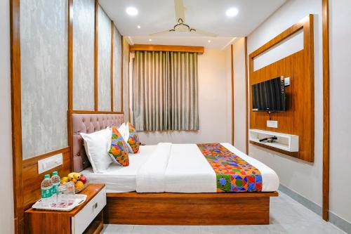孟买Hotel Affari的一间卧室配有一张床和一张带水果的桌子