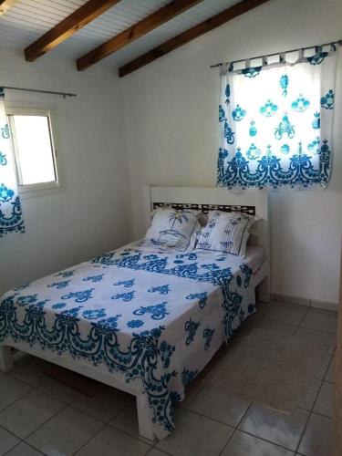 黑角Villa des fleurs的一间卧室配有蓝色和白色床单