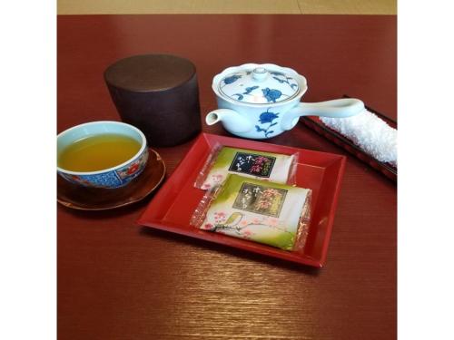 雫石町Oshuku Onsen Hotel Uguisu - Vacation STAY 27299v的茶几和红盘