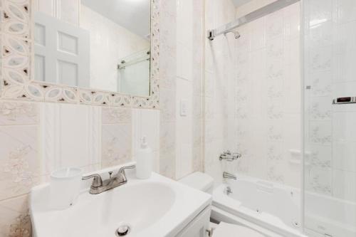 布鲁克林Bay Ridge Elegance: Luxe Hotel Getaway的白色的浴室设有水槽和镜子