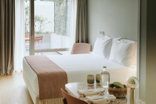 蓬塔德尔加达NINE DOTS Azorean Art Boutique Hotel的酒店客房配有一张床、一张桌子和毛巾