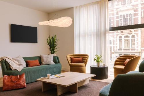 鹿特丹Sonder Rose的客厅配有沙发、椅子和桌子