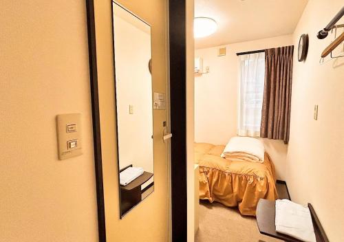 对马市Hotel MitsuWakan - Vacation STAY 87402v的一间设有镜子和一张床的房间