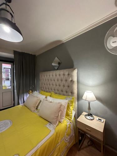 里斯本apartamet in Bairro alto 1的一间卧室配有黄色的床和一盏灯