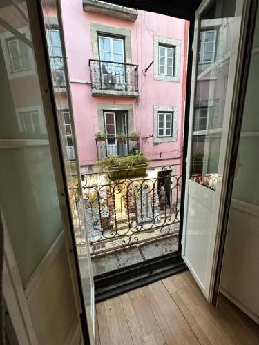 里斯本apartamet in Bairro alto 1的从窗口可欣赏到粉红色建筑的景色