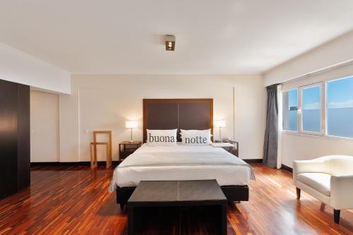玛德琳港托洛萨酒店的酒店客房带一张大床和一把椅子