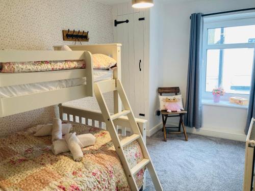 AdlingtonAdlington Cottage, Lancashire的一间卧室设有两张双层床和一扇窗户。