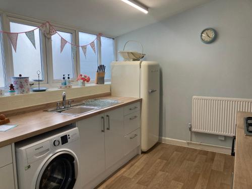 AdlingtonAdlington Cottage, Lancashire的厨房配有冰箱和洗衣机。