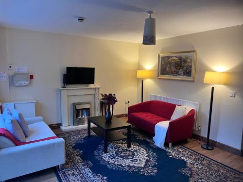贝尔法斯特Prestashortstays的客厅设有红色的沙发和壁炉