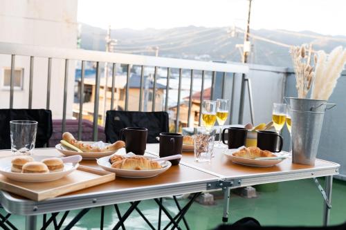 热海Atami-Ajironokaze - Vacation STAY 87959v的餐桌,带食物盘和酒杯