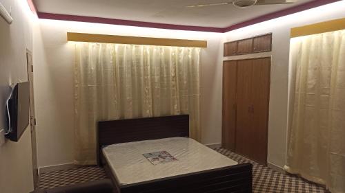 达卡Signature Home的小房间设有一张床和一个衣柜